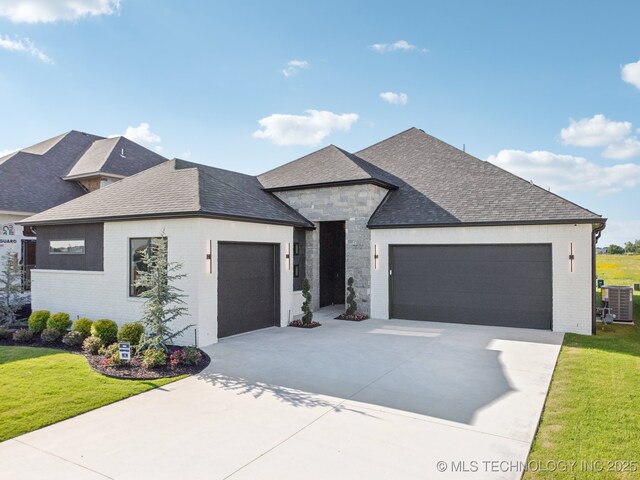 2357 E 134th Cir, Bixby, OK 74008 - view of front of house featuring a garage, concrete driveway, a front yard, brick siding, and a shingled roof