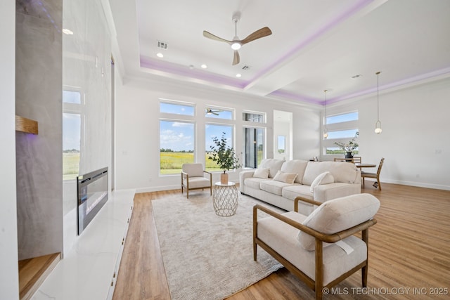 2357 E 134th Cir, Bixby, OK 74008 - living area with a raised ceiling, a ceiling fan, light wood-style flooring, a premium fireplace, and recessed lighting