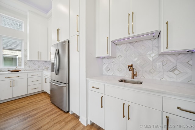 2357 E 134th Cir, Bixby, OK 74008 - kitchen featuring stainless steel refrigerator with ice dispenser, backsplash, white cabinets, light wood finished floors, and light stone counters