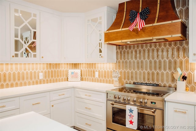 2232 Gershwin Dr, Durant, OK 74701 - kitchen with electric stove, premium range hood, tasteful backsplash, white cabinetry, and light countertops