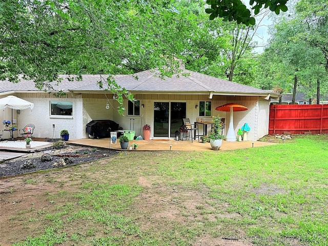2232 Gershwin Dr, Durant, OK 74701 - back of house with a patio area, brick siding, roof with shingles, and an attached carport