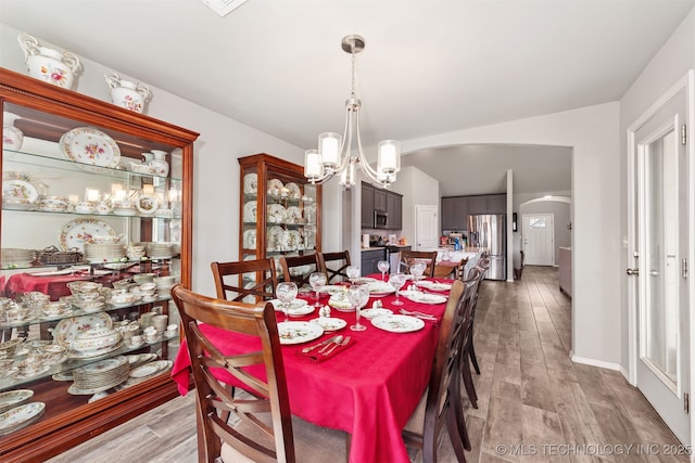 10101 S 232nd E Ave, Broken Arrow, OK 74014 - dining room with arched walkways, wood finished floors, a chandelier, and baseboards