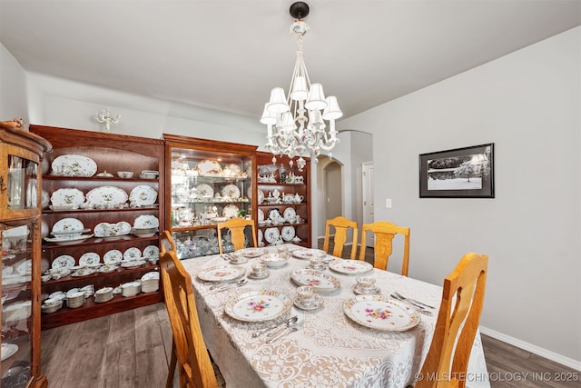 10101 S 232nd E Ave, Broken Arrow, OK 74014 - dining space featuring arched walkways, wood finished floors, a chandelier, and baseboards