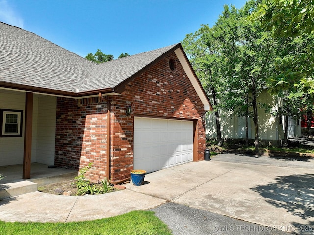 46 Acorn St, Eufaula, OK 74432 - view of property exterior featuring roof with shingles, brick siding, an attached garage, and driveway