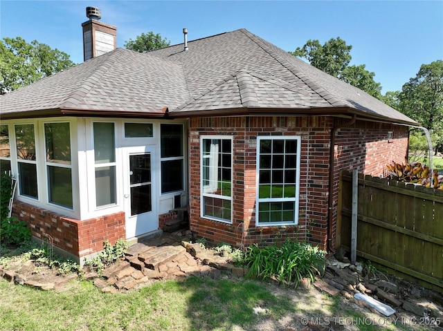 46 Acorn St, Eufaula, OK 74432 - rear view of property featuring brick siding, a shingled roof, and a chimney