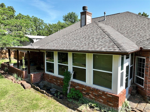 46 Acorn St, Eufaula, OK 74432 - view of side of property featuring brick siding, roof with shingles, a chimney, a patio, and a yard