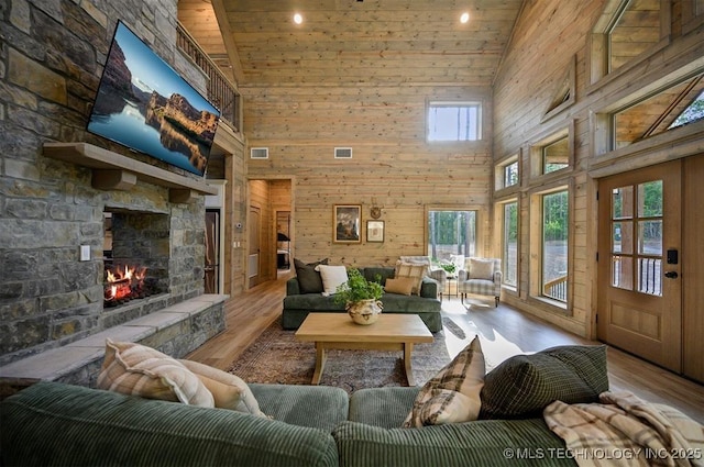 475 Bear Pine Trl, Broken Bow, OK 74728 - living area featuring high vaulted ceiling, a stone fireplace, wood finished floors, wood walls, and wood ceiling