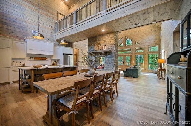 475 Bear Pine Trl, Broken Bow, OK 74728 - dining room with a high ceiling, light wood-style floors, wooden ceiling, and wood walls