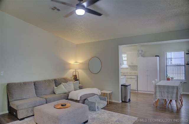 13866 S Nyssa Pl, Glenpool, OK 74033 - living area with a ceiling fan, wood finished floors, a textured ceiling, and baseboards