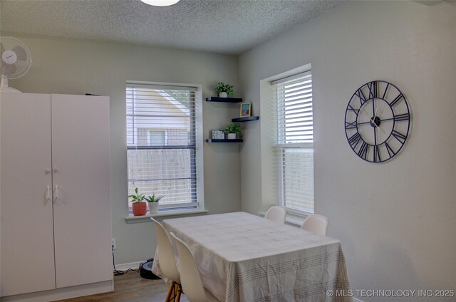 13866 S Nyssa Pl, Glenpool, OK 74033 - dining area with dark wood finished floors, a textured ceiling, and baseboards