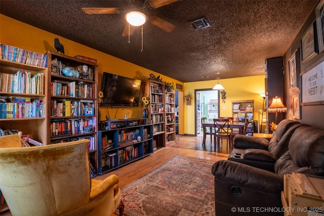 420 E Elm St, Skiatook, OK 74070 - living area featuring ceiling fan, wood finished floors, and a textured ceiling