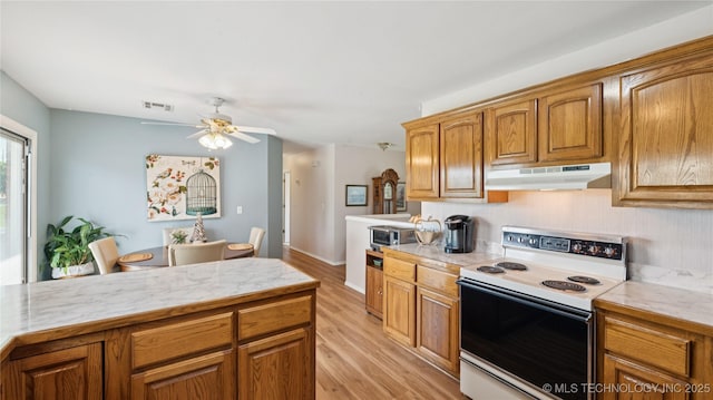 30955 S 4240th Rd, Inola, OK 74036 - kitchen featuring white electric range, under cabinet range hood, light countertops, and light wood finished floors