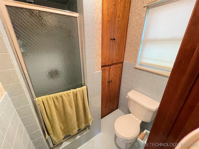 116800 S 4300th Rd, Porum, OK 74455 - full bathroom featuring a shower stall, toilet, tile walls, and a wainscoted wall