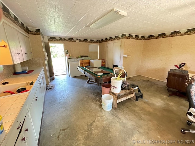 116800 S 4300th Rd, Porum, OK 74455 - kitchen with tile counters, pool table, concrete floors, washer and clothes dryer, and white cabinets