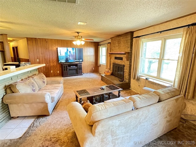 116800 S 4300th Rd, Porum, OK 74455 - carpeted living room featuring a fireplace, a textured ceiling, wooden walls, and a ceiling fan