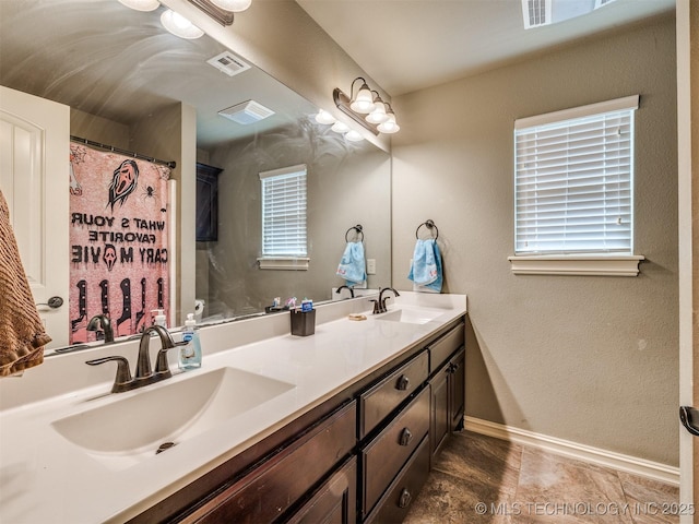 18210 E 49th St, Tulsa, OK 74134 - full bathroom featuring double vanity, baseboards, a textured wall, and plenty of natural light