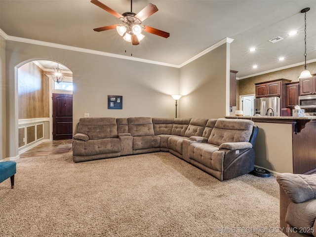 18210 E 49th St, Tulsa, OK 74134 - living room featuring light carpet, recessed lighting, arched walkways, ceiling fan, and ornamental molding