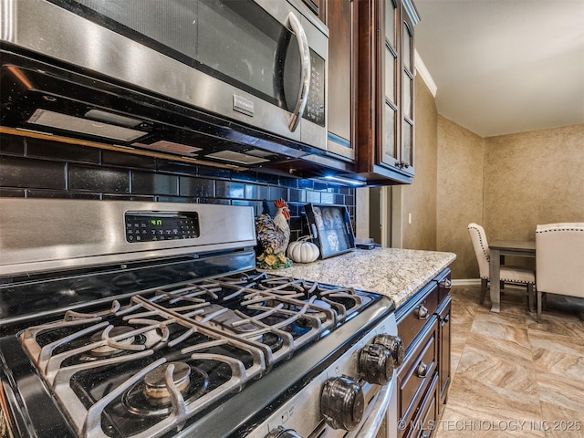 18210 E 49th St, Tulsa, OK 74134 - kitchen featuring stainless steel appliances, backsplash, dark brown cabinets, light stone countertops, and glass insert cabinets