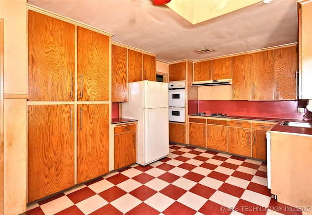 464 S Allegheny Ave, Tulsa, OK 74112 - kitchen with tile patterned floors, white appliances, range hood, a sink, and brown cabinets