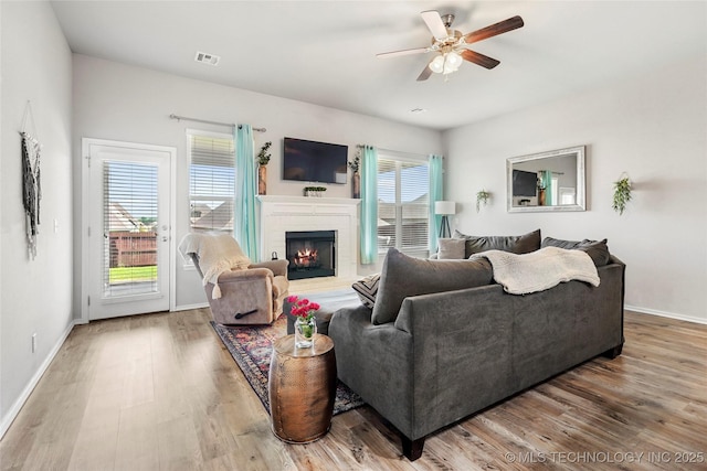 2023 E 133rd St S, Bixby, OK 74008 - living area featuring wood finished floors, a ceiling fan, a lit fireplace, and baseboards