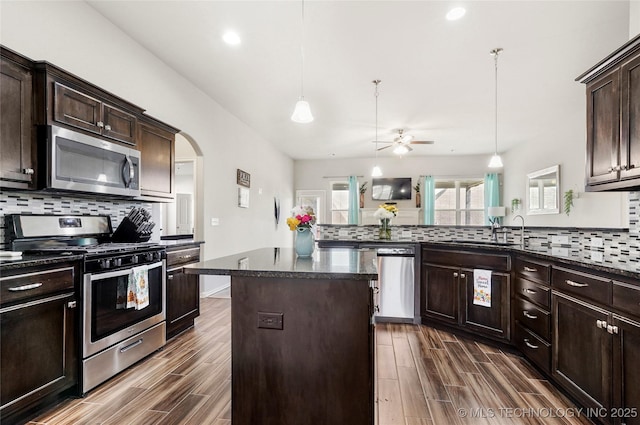 2023 E 133rd St S, Bixby, OK 74008 - kitchen with appliances with stainless steel finishes, ceiling fan, decorative backsplash, a sink, and a center island