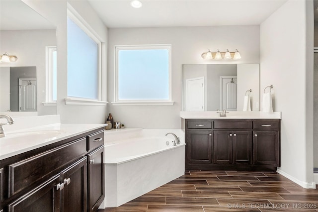 2023 E 133rd St S, Bixby, OK 74008 - full bathroom featuring two vanities, a garden tub, wood finished floors, and recessed lighting