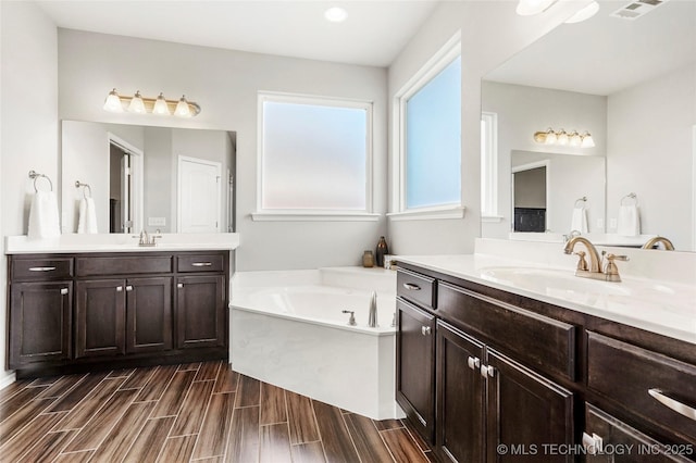 2023 E 133rd St S, Bixby, OK 74008 - bathroom featuring two vanities, a bath, and wood tiled floors