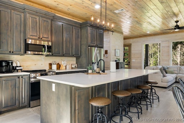 62 Hickory Canyon Trl, Broken Bow, OK 74728 - kitchen featuring appliances with stainless steel finishes, wooden ceiling, open floor plan, light wood-style flooring, and a kitchen breakfast bar