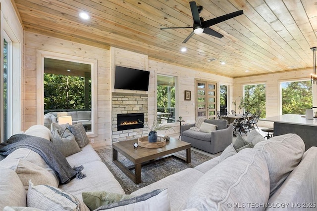 62 Hickory Canyon Trl, Broken Bow, OK 74728 - living room featuring wood ceiling, wooden walls, ceiling fan, recessed lighting, and a lit fireplace