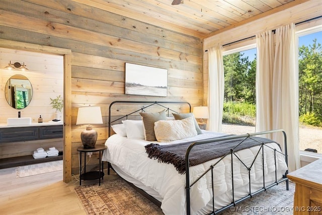 62 Hickory Canyon Trl, Broken Bow, OK 74728 - bedroom featuring wooden ceiling, wooden walls, wood finished floors, connected bathroom, and access to outside