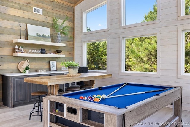 62 Hickory Canyon Trl, Broken Bow, OK 74728 - rec room featuring wood walls, light wood-style floors, a towering ceiling, and bar