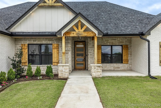 5769 S 256th E Ave, Broken Arrow, OK 74014 - property entrance with board and batten siding, a shingled roof, a yard, and stone siding