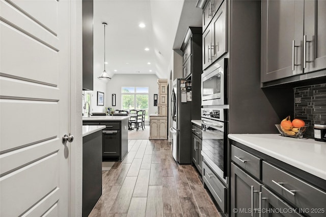 8617 E Hartford St, Broken Arrow, OK 74014 - kitchen with appliances with stainless steel finishes, light countertops, wood finished floors, backsplash, and recessed lighting