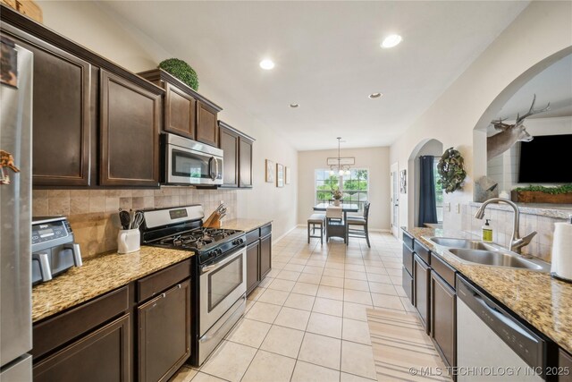 2704 W Imperial St, Broken Arrow, OK 74011 - kitchen with stainless steel appliances, a sink, tasteful backsplash, dark brown cabinetry, and recessed lighting