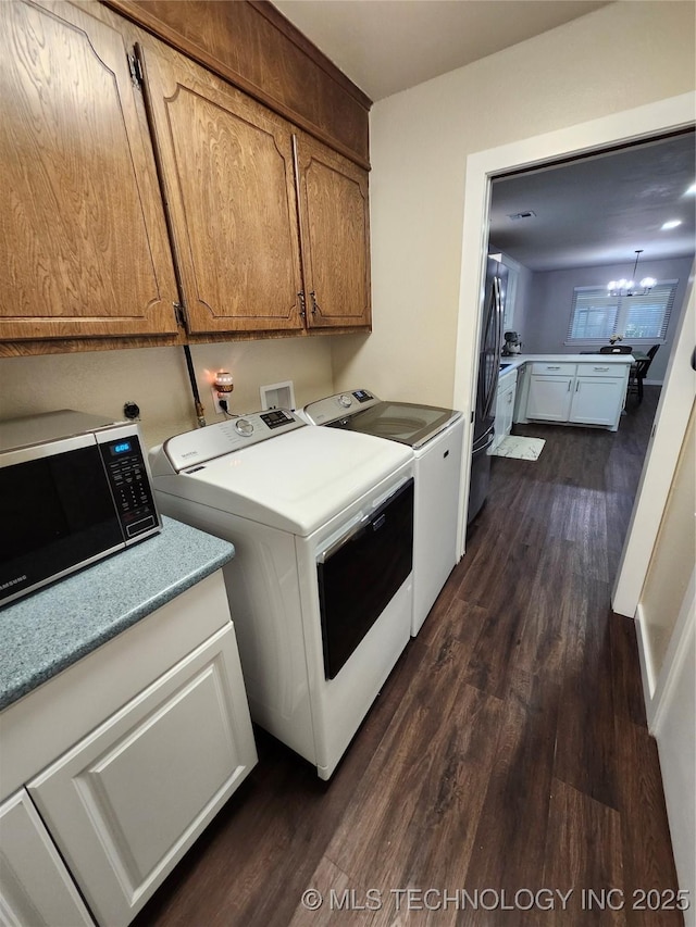 2230 Robin Ln, Muskogee, OK 74403 - laundry area featuring washer and clothes dryer, dark wood finished floors, cabinet space, and a chandelier