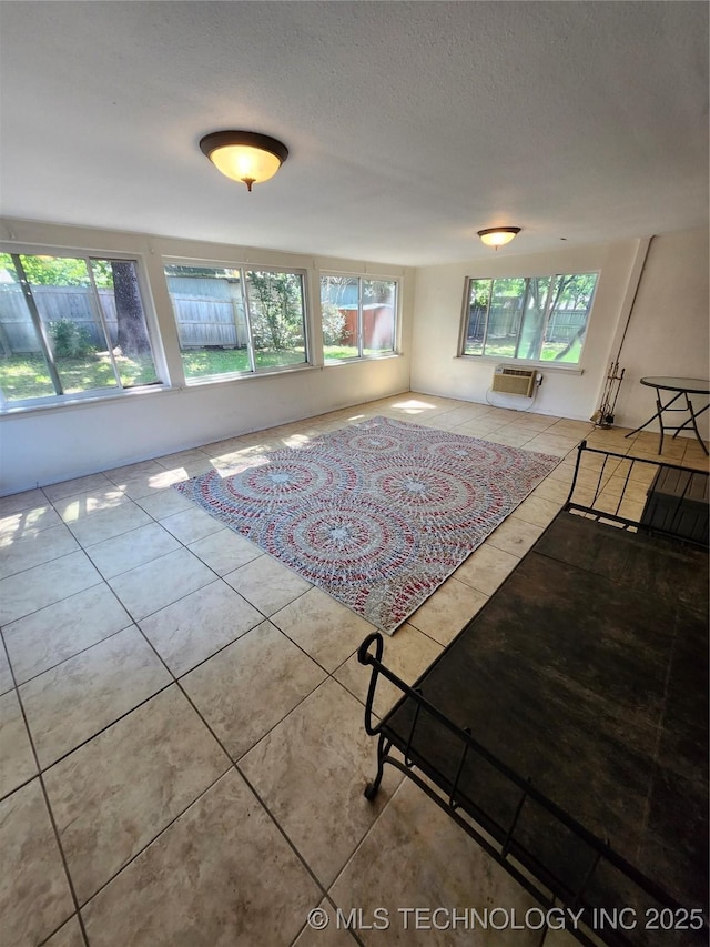 2230 Robin Ln, Muskogee, OK 74403 - living area featuring plenty of natural light, a wall unit AC, tile patterned floors, and a textured ceiling