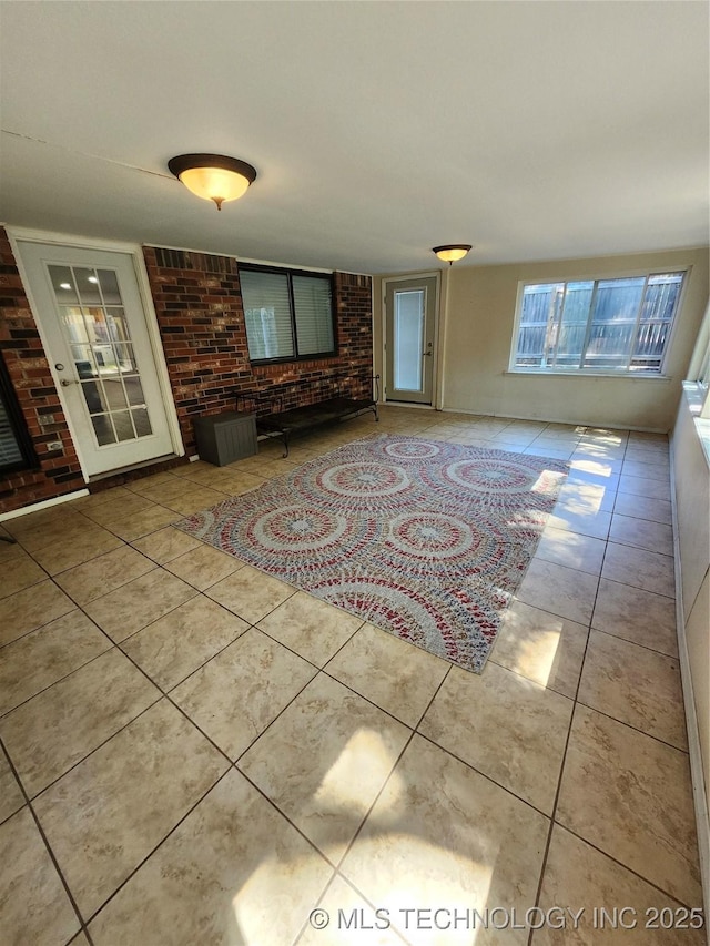 2230 Robin Ln, Muskogee, OK 74403 - unfurnished living room with brick wall and tile patterned flooring