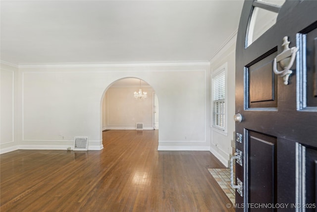 1648 S Evanston Ave, Tulsa, OK 74104 - entrance foyer featuring arched walkways, a chandelier, crown molding, wood finished floors, and baseboards