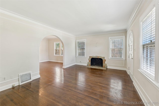 1648 S Evanston Ave, Tulsa, OK 74104 - unfurnished living room featuring arched walkways, a fireplace with flush hearth, wood finished floors, ornamental molding, and baseboards