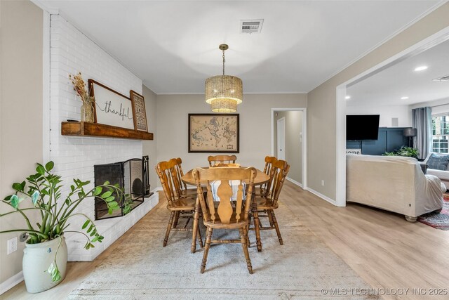 4023 E 36th St S, Tulsa, OK 74135 - dining space with light wood finished floors, a brick fireplace, recessed lighting, ornamental molding, and a chandelier
