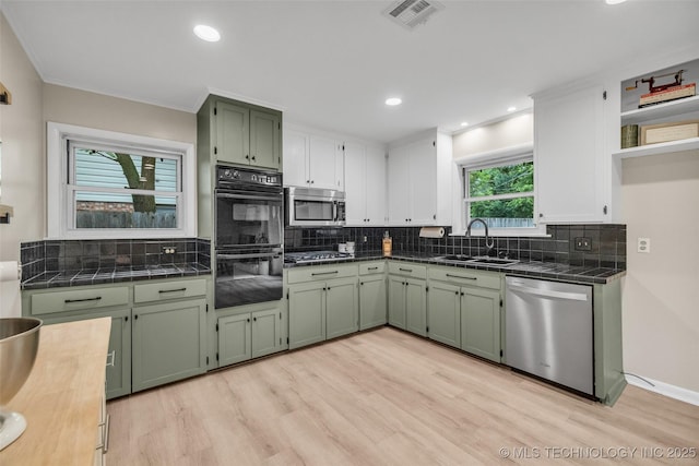 4023 E 36th St S, Tulsa, OK 74135 - kitchen with appliances with stainless steel finishes, green cabinets, light wood-type flooring, decorative backsplash, and recessed lighting
