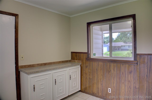 5764 E 30th Pl, Tulsa, OK 74114 - kitchen with wainscoting, wood walls, light tile patterned flooring, and crown molding