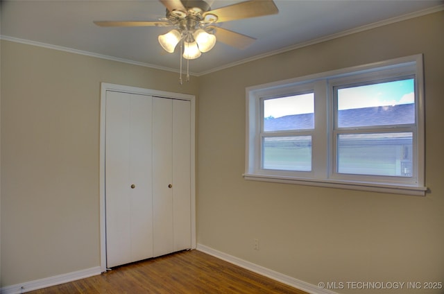 5764 E 30th Pl, Tulsa, OK 74114 - unfurnished bedroom featuring baseboards, dark wood-type flooring, a closet, crown molding, and ceiling fan