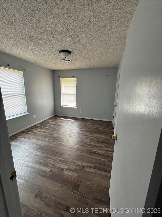 1310 S 38th St, Muskogee, OK 74401 - spare room with wood finished floors, a textured ceiling, and baseboards