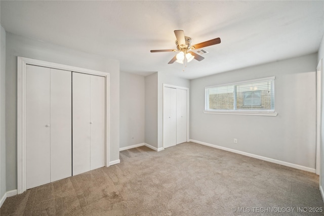 1703 Elm St, Owasso, OK 74055 - unfurnished bedroom featuring two closets, carpet, baseboards, and ceiling fan