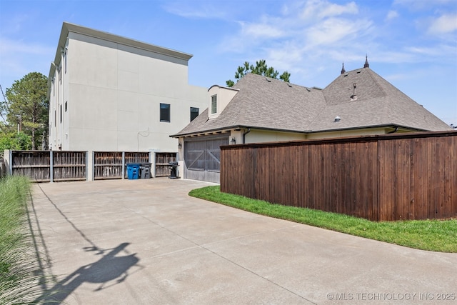1336 E 35th Pl, Tulsa, OK 74105 - view of side of property featuring roof with shingles and driveway