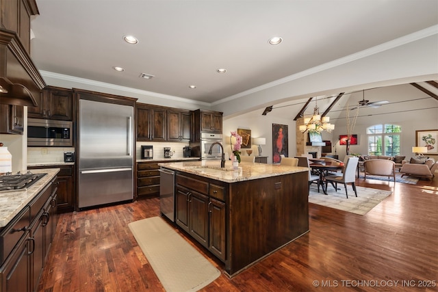 1336 E 35th Pl, Tulsa, OK 74105 - kitchen featuring built in appliances, open floor plan, a sink, decorative backsplash, and dark brown cabinetry