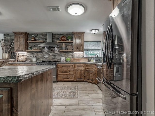 32188 E 738th Rd, Wagoner, OK 74467 - kitchen featuring appliances with stainless steel finishes, open shelves, wall chimney exhaust hood, dark countertops, and tasteful backsplash