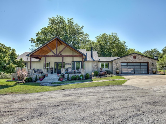32188 E 738th Rd, Wagoner, OK 74467 - view of front of property featuring stone siding, concrete driveway, an attached garage, a front yard, and covered porch