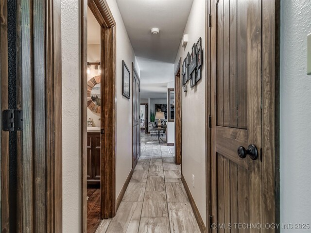 32188 E 738th Rd, Wagoner, OK 74467 - corridor featuring light marble finish floors and baseboards